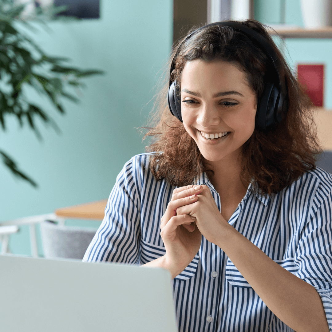 A professional woman smiling while attentively using a computer for learning.