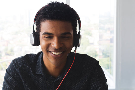 Man wearing headphones, attentively listening to audio content.