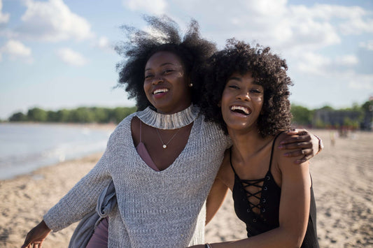 Two female friends laughing on the beach