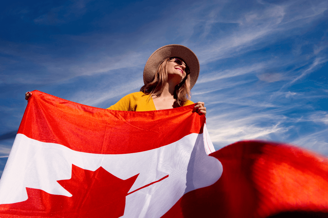 A happy student holding a Canadian flag, celebrating achieving NCLC 7 on the TEF Canada exam for Express Entry.